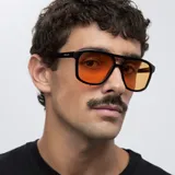 Lentes de sol de aviador con montura negra y lentes naranjas. Fabricados con materiales bio-based G850 y patillas de propionato de celulosa. Cuentan con protección UV400.