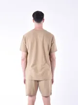 Remera color beige con diseño de rayas horizontales y logo estampado en el pecho.