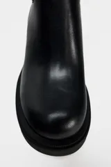 Botín Chelsea negro de cuero con caña de neopreno, tacón bloque y suela track.