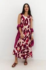 Vestido midi sin mangas, con cuello redondo, estampado animal print en tonos rojo, bordó y beige. Presenta cortes diagonales en el cuerpo que añaden estructura al diseño.