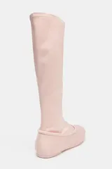 Bota alta plana color rosa pálido, con acabado satinado y punta redonda. Presenta un detalle de pespunte en la unión del cuerpo con la base.
