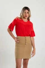 Falda corta color beige con botones frontales y bolsillos laterales.