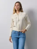 Cárdigan tejido negro con cuello con solapa y abertura central con cierre. Delantera con bolsillos simulados.