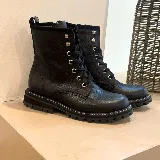 Borcego de cuero negro con cordones y suela track.