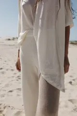 Poncho blanco de lino con cuello redondo y mangas 3/4.