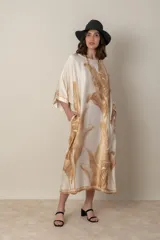 Vestido italiano tipo túnica, suelto, de satén color natural con estampado de hojas de palma en tonos marrones. Tiene bolsillos laterales.