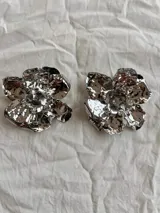 Par de aros dorados con forma de flor con textura martillada.