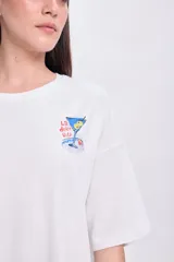 Remera blanca de corte amplio con mangas cortas y estampado en la espalda con la palabra "Italy", un aperitivo, una copa y la frase "La dolce vita".