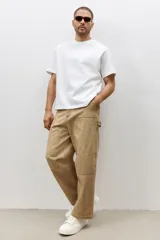 Remera blanca de algodón pesado, corte holgado, con cuello redondo ribeteado, hombros caídos y bajo recto.