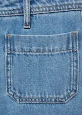 Pantalón largo de denim, color celeste claro, de tiro alto y pierna ancha. Presenta dos bolsillos de parche delanteros y dos bolsillos traseros.