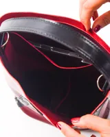 Bolso matero color bordó, de cuero, con doble asa (una de mano y otra larga desmontable), divisor interno para termo y mate, y bolsillo interior.