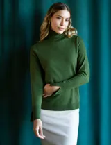 Polera de punto fino marca Nienty, color blanco, con cuello alto volcado y mangas largas con detalle de tajo en los puños.