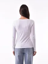 Remera blanca de manga larga con cuello redondo y estampado abstracto en tonos pastel.