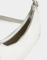 Bandolera color blanco crudo de cuerina, con asa de hombro y pouch lateral con cierre y charm de metal.