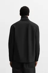 Camisa color crema de corte regular fit, confeccionada en tejido con viscosa. Tiene cuello solapa, manga larga con puños abotonados, bolsillo de parche en el pecho y cierre frontal con botones.