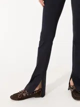 Pantalón negro de punto liso, con cintura elastizada y tajos laterales en el ruedo.