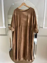 Vestido largo de pana fina color verde con estampado de flores marrones, corte oversize, mangas 3/4 y bolsillos laterales.