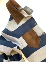 Camisa de lana merino a rayas horizontales azul marino y gris, con cuello clásico y bolsillo de parche en cuero marrón.