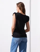 Remera negra de modal con escote en V y aplique de puntilla en mangas y escote. Detalle fruncido en hombros.