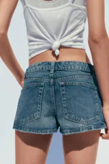 Short de jean de tiro medio, con cinco bolsillos y cierre frontal con cremallera y botón metálico.