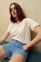 Remera color rosa claro de manga corta y cuello redondo.