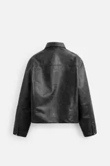 Cazadora cropped fit confeccionada en tejido efecto piel color negro. Tiene cuello solapa, manga larga con puño abotonado, bolsillos de vivo en cadera, bolsillo interior y cierre frontal con botones a presión.