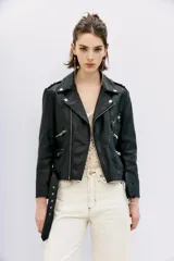 Campera negra de cuero ovino, estilo rocker, con cinturón, charreteras y solapas. Tiene cierres y detalles metálicos en frente y espalda.