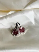 Par de aros colgantes con argolla de acero quirúrgico, dije circular de resina negra y borde de strass plateado.