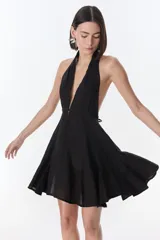 Vestido corto fucsia con escote halter y espalda descubierta.