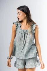 Conjunto de pijama de algodón estampado con flores, compuesto por una musculosa de escote recto con frunces y un short con elástico en la cintura y volados en el ruedo.