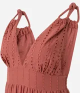 Vestido midi de corte evasé confeccionado en tejido laise de algodón. Presenta escote en V con busto fruncido, breteles finos torcidos con nudos y falda con recortes fruncidos y bordados calados.