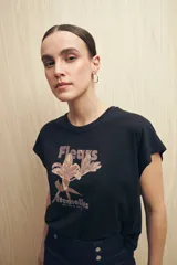 Remera negra de manga corta con estampado floral y tipográfico en tonos marrones.