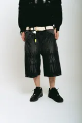 Bermuda de jean negro con lavado ácido gris, corte baggy y bolsillos grandes. Presenta bordados plateados y blancos, cierres y botón personalizado.