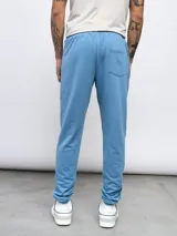 Pantalón de jogging gris de felpa sin friza, con cintura elástica ajustable con cordón y logo de Umbro estampado en blanco en el muslo izquierdo.