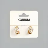 Aros tipo argolla plateados con tres aros paralelos, con incrustaciones de strass y una perla.