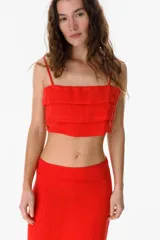 Top corto rojo con tirantes finos y diseño de capas superpuestas.