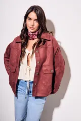 Sobrecamisa color borgoña de gamuza sintética con cuello camisero, cierre frontal con botones a tono, bolsillos de parche con solapa en el pecho y mangas largas con puños abotonados.