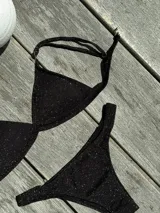 Conjunto de bikini turquesa con corpiño triangular de corte fijo, breteles regulables y almohadillas desmontables, y bombacha vedetina con frunce elástico en los costados.