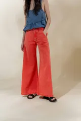 Pantalón de jean color naranja con tiro medio y pierna ancha.