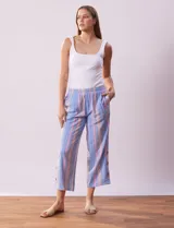 Pantalón capri de algodón a rayas verticales celestes, rosadas y beige. Tiene pretina elastizada, bolsillos delanteros y ruedo con botones.