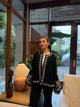 Campera blanca de algodón con bordados florales en color crema, corte recto y mangas acampanadas.