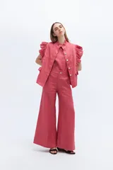 Chaleco celeste de lino con cuello mao, cierre frontal con botones y volados en hombros y bolsillos.