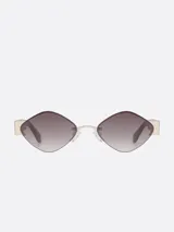 Lentes de sol Carolina Lemke con forma geométrica de diamante, con marco metálico dorado y lentes degradadas de marrón a transparente.