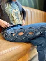 Pantalón de jean azul de tiro medio con diseño trenzado lateral.