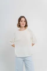 Buzo de tejido fino color blanco, con mangas 3/4, escote redondo y calce relajado.