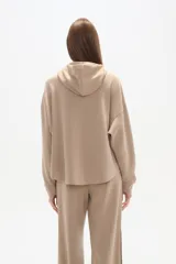 Buzo negro con capucha, cuello alto con broches, manga larga y bolsillo canguro frontal.