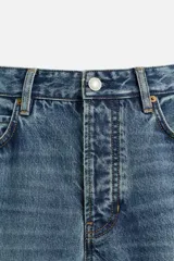 Pantalón de jean celeste de corte recto, con cinco bolsillos, efecto lavado y cierre frontal con botones.
