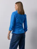 Camisa blanca de algodón marca Zac & Rachel, con cuello con solapa, abertura central con botones, delantera tableada y laterales elastizados.
