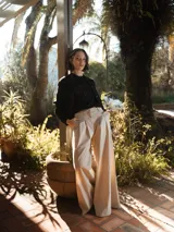 Pantalón oversize de pierna ancha color beige, con pliegues y bolsillos laterales.