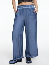 Pantalón amplio de viscosa color azul, teñida en frío con efecto gastado. De calce relajado y cintura con elástico, ofrece máxima comodidad.